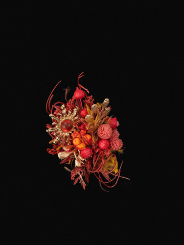 The Sun Flower Ring by CAMELLIA features a vibrant array of red and orange flowers with natural elements against a black backdrop. Handcrafted in New York, it beautifully captures the elegance and artistry reminiscent of a custom symbol flower ring. The Sun Flower Ring by CAMELLIA features a vibrant array of red and orange flowers with natural elements against a black backdrop. Handcrafted in New York, it beautifully captures the elegance and artistry reminiscent of a custom symbol flower ring.