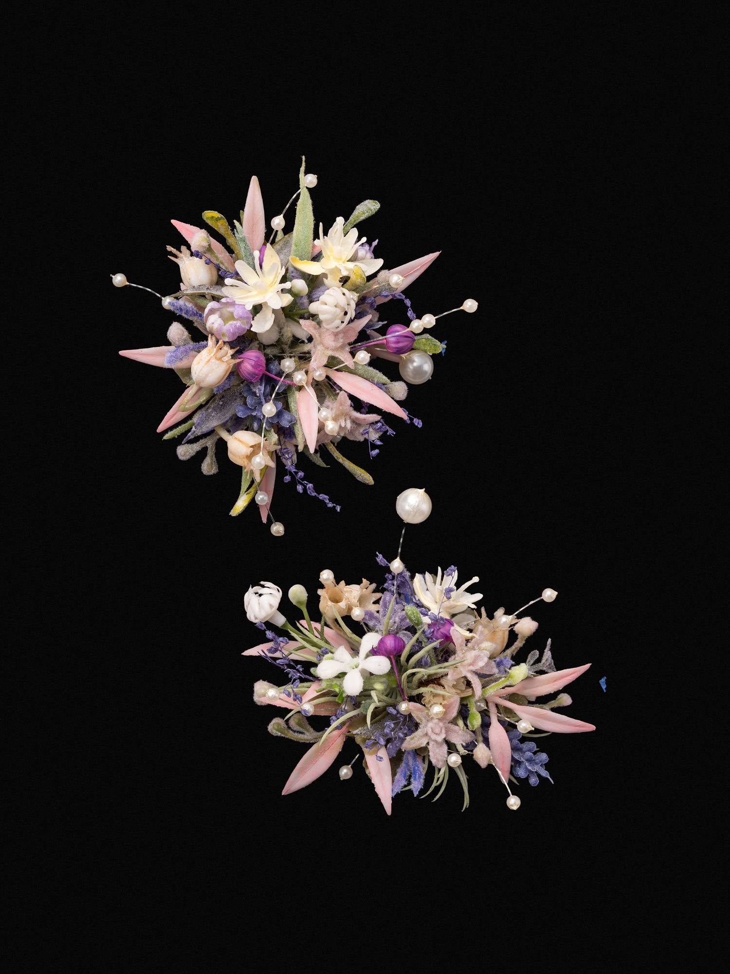 The CAMELLIA Korean Purple Wedding Flower Rings showcase two clusters of assorted preserved flowers and leaves, featuring pink, white, and purple blooms elegantly arranged against a black background.