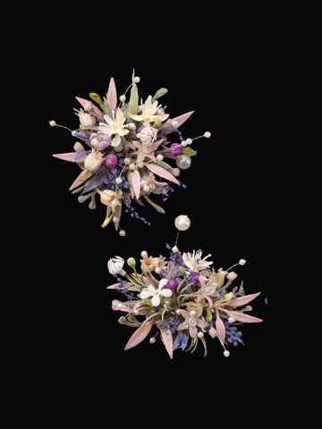 The CAMELLIA Korean Purple Wedding Flower Rings showcase two clusters of assorted preserved flowers and leaves, featuring pink, white, and purple blooms elegantly arranged against a black background. The CAMELLIA Korean Purple Wedding Flower Rings showcase two clusters of assorted preserved flowers and leaves, featuring pink, white, and purple blooms elegantly arranged against a black background.