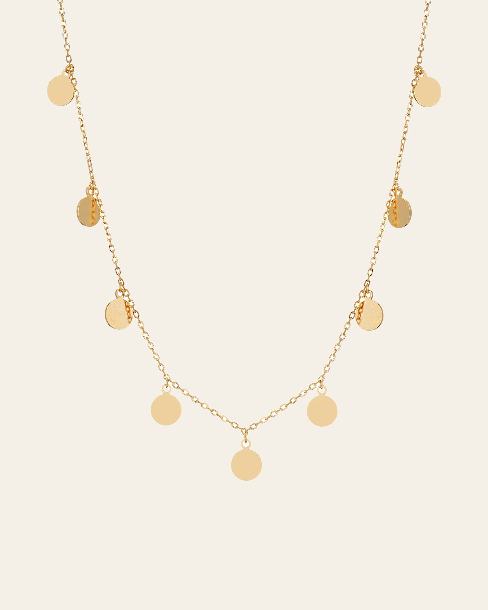 The CAMELLIA Mother Chain Necklace is crafted in 14K yellow gold vermeil, showcasing round disc pendants elegantly dangling from a delicate chain.