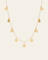 The CAMELLIA Mother Chain Necklace is crafted in 14K yellow gold vermeil, showcasing round disc pendants elegantly dangling from a delicate chain.