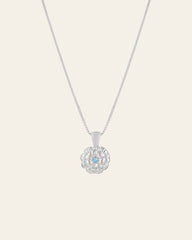 The Elsa Marigold Tourmaline Necklace by CAMELLIA is expertly crafted from hypoallergenic sterling silver and highlighted with a flower-shaped pendant featuring a central light blue gemstone.