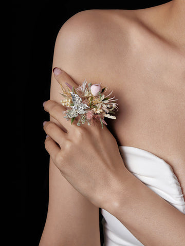 A person in a white strapless top holds the CAMELLIA Butterfly Flower Ring against their shoulder, displayed against a black background. A person in a white strapless top holds the CAMELLIA Butterfly Flower Ring against their shoulder, displayed against a black background.