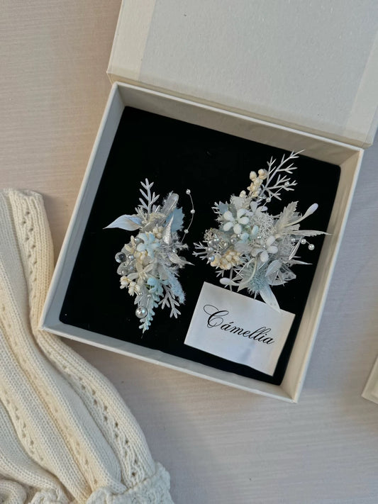 A white box with two delicate floral hairpins and a card labeled