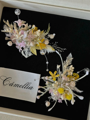 Elegant floral arrangements with pastel flowers and foliage on a black background, featuring customizable elements like a fabric label displaying "CAMELLIA," adorn the Customized Unique Flower Ring. Elegant floral arrangements with pastel flowers and foliage on a black background, featuring customizable elements like a fabric label displaying "CAMELLIA," adorn the Customized Unique Flower Ring.