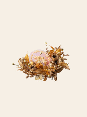 The CAMELLIA Melaleuca Bracteata Birth Flower Ring features a decorative arrangement of gold artificial flowers, leaves, and beads encircling a translucent orb with a floral design. The CAMELLIA Melaleuca Bracteata Birth Flower Ring features a decorative arrangement of gold artificial flowers, leaves, and beads encircling a translucent orb with a floral design.