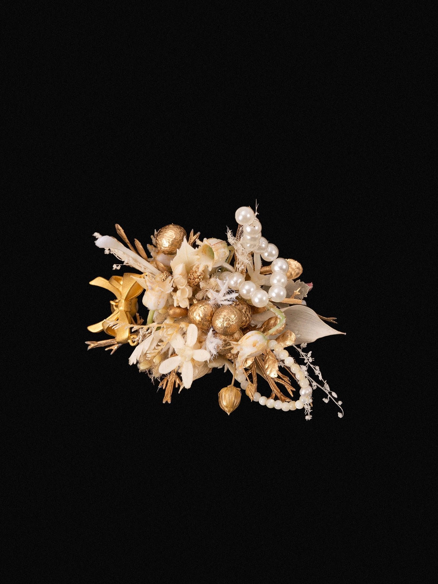 The CAMELLIA Pearl Flower Ring features a handcrafted decorative arrangement of golden and white flowers with pearls on a black background, customizable to suit your style.