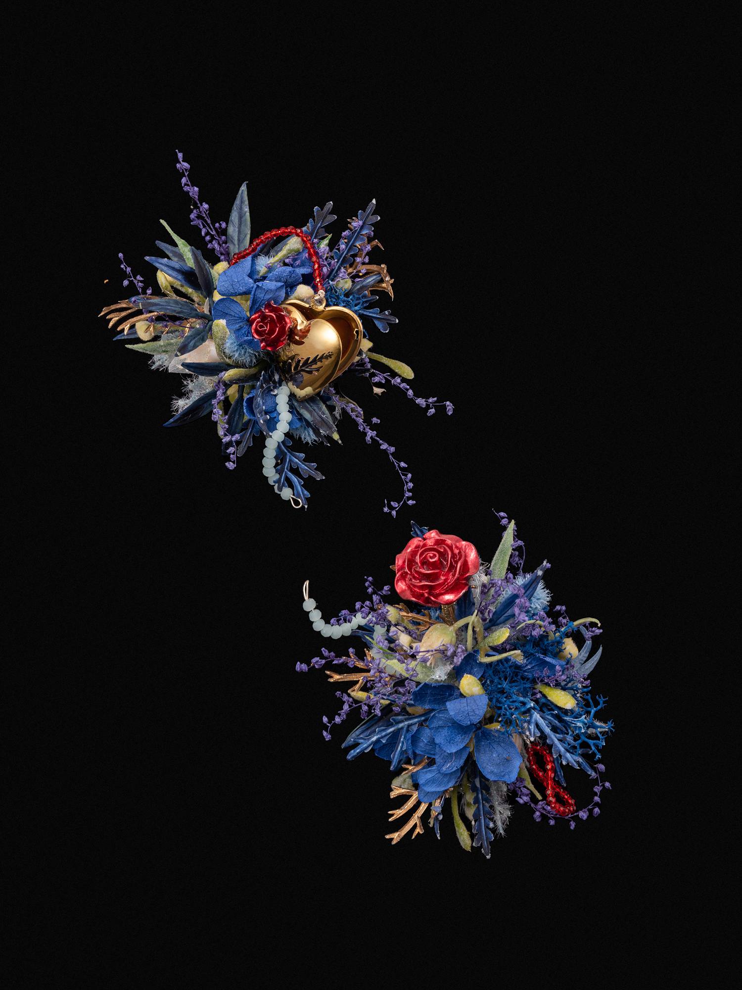 The Little Prince Wedding Flower Rings by CAMELLIA feature two floral arrangements of blue and red flowers with gold accents and greenery on a black background, spaced diagonally, showcasing the meticulous craftsmanship typical of New York handmade items.
