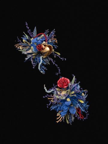 The Little Prince Wedding Flower Rings by CAMELLIA feature two floral arrangements of blue and red flowers with gold accents and greenery on a black background, spaced diagonally, showcasing the meticulous craftsmanship typical of New York handmade items. The Little Prince Wedding Flower Rings by CAMELLIA feature two floral arrangements of blue and red flowers with gold accents and greenery on a black background, spaced diagonally, showcasing the meticulous craftsmanship typical of New York handmade items.