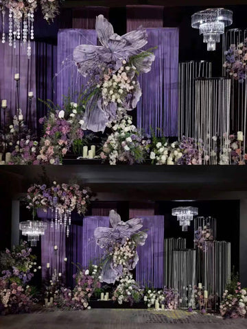 The CAMELLIA Korean Purple Wedding Flower Rings are showcased in an elegant floral and fabric display with purple drapes, white and purple flowers, candles, and chandeliers. This handcrafted ring stands out against a dark backdrop in a layered, symmetrical pattern amidst preserved flowers. The CAMELLIA Korean Purple Wedding Flower Rings are showcased in an elegant floral and fabric display with purple drapes, white and purple flowers, candles, and chandeliers. This handcrafted ring stands out against a dark backdrop in a layered, symmetrical pattern amidst preserved flowers.