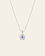 The CAMELLIA Elsa Holly Tanzanite Necklace features a sterling silver flower-shaped pendant with a center tanzanite gemstone. It's hypoallergenic, offering comfort throughout the day.