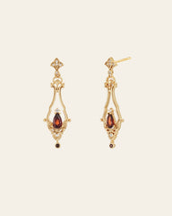The Sophina Garnet Earrings by CAMELLIA feature gold ornate diamond-shaped tops with garnet teardrop gemstones, crafted in 14K Yellow Gold Vermeil against a plain background.