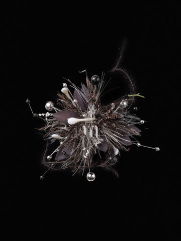 A complex handcrafted abstract sculpture resembling a cluster, featuring metallic pins, dark leaves, feathers, and a white central element against a black background. The piece evokes the intricate elegance of CAMELLIA's Scorpio Flower Ring or an adjustable custom symbol flower ring. A complex handcrafted abstract sculpture resembling a cluster, featuring metallic pins, dark leaves, feathers, and a white central element against a black background. The piece evokes the intricate elegance of CAMELLIA's Scorpio Flower Ring or an adjustable custom symbol flower ring.