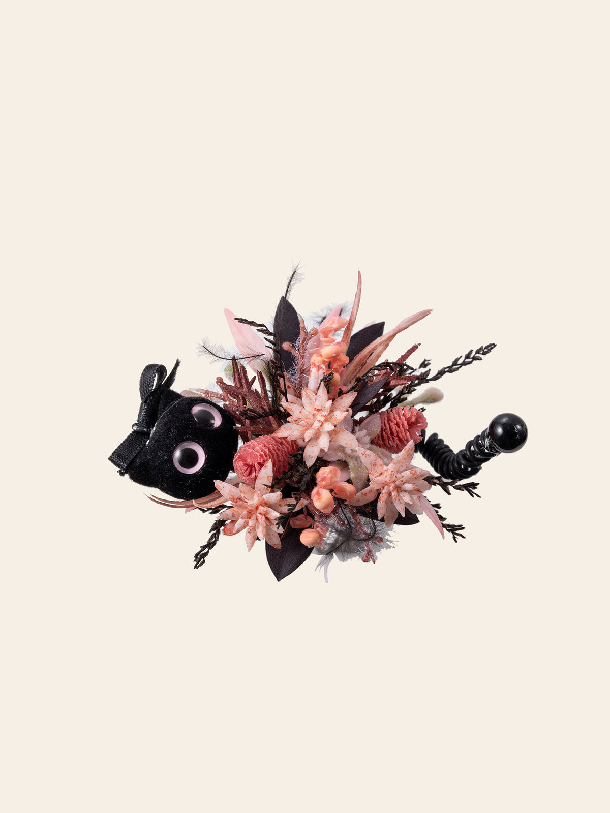The CAMELLIA Cat Flower Ring is a handcrafted decorative bouquet with pink and brown dried flowers, featuring a small black plush cat with large eyes and a black handle.