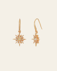 The Stella Radiance Opal Dangle Earrings by CAMELLIA are exquisite yellow gold earrings with a sunburst design, accented by small gemstones and opal centers against a plain backdrop.