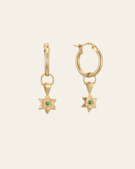 The CAMELLIA Elsa Lily Emerald Earrings feature two 14K Yellow Gold Vermeil hoop earrings with star-shaped pendants and green gemstones. Set against a light background, these hypoallergenic pieces blend style and comfort for sensitive ears.