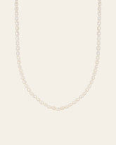 The CAMELLIA 3mm Pearl Chain Necklace features a strand of white pearls elegantly paired with a 14K Yellow Gold Vermeil clasp, set against a plain light background.