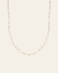 The CAMELLIA 3mm Pearl Chain Necklace features a strand of white pearls elegantly paired with a 14K Yellow Gold Vermeil clasp, set against a plain light background.