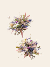 The Korean Purple Wedding Flower Rings by CAMELLIA exude elegance with two symmetrical floral arrangements of pastel flowers, green leaves, and small decorative pearls on a light background, reminiscent of a handcrafted wedding ring.