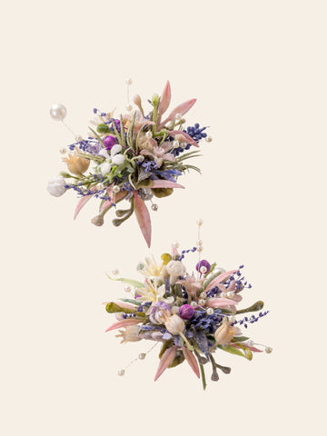 The Korean Purple Wedding Flower Rings by CAMELLIA exude elegance with two symmetrical floral arrangements of pastel flowers, green leaves, and small decorative pearls on a light background, reminiscent of a handcrafted wedding ring. The Korean Purple Wedding Flower Rings by CAMELLIA exude elegance with two symmetrical floral arrangements of pastel flowers, green leaves, and small decorative pearls on a light background, reminiscent of a handcrafted wedding ring.
