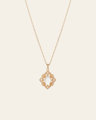 The CAMELLIA Capri Moonstone Necklace showcases an oval white moonstone pendant at its center, enhanced by intricate 14K yellow gold vermeil detailing on a gold chain.