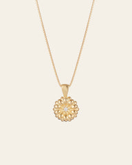 The Elsa Daisy Diamond Necklace by CAMELLIA features a delicate 14K Yellow Gold Vermeil chain and a round pendant with a central diamond-like gem. Handcrafted in New York, it's an elegant piece that adds timeless charm to any outfit.