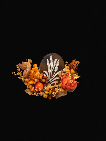 The Wheat Birth Flower Ring by CAMELLIA features a decorative oval stone with a white wheat design, surrounded by autumn-themed artificial foliage and berries against a black background, blending nature's elegance with handcrafted artistry from New York. The Wheat Birth Flower Ring by CAMELLIA features a decorative oval stone with a white wheat design, surrounded by autumn-themed artificial foliage and berries against a black background, blending nature's elegance with handcrafted artistry from New York.