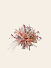 The Confession Valentine’s Day Flower Ring by CAMELLIA, handcrafted in New York, features a bouquet of pastel flowers with heart-shaped decorations, silver metallic accents, and dried preserved blooms for timeless elegance.