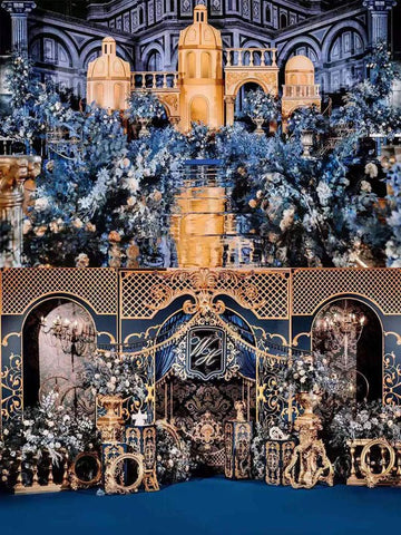 An opulent indoor scene boasts lavish gold and blue decor featuring CAMELLIA's Blue and Gold Baroque Castle Wedding Flower Rings, with intricate preserved floral arrangements and ornate architectural elements. An opulent indoor scene boasts lavish gold and blue decor featuring CAMELLIA's Blue and Gold Baroque Castle Wedding Flower Rings, with intricate preserved floral arrangements and ornate architectural elements.