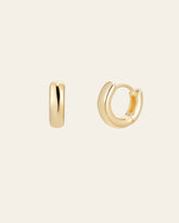 The Mia Hoops by CAMELLIA, two elegant small gold hoop earrings in 14K Yellow Gold Vermeil, are displayed on a plain background. One lies on its side while the other is partially open.