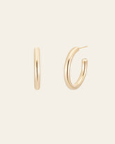 The CAMELLIA Zoe Hoops are displayed on a neutral background, showcasing one from the front and another from the side in 14K Yellow Gold Vermeil.