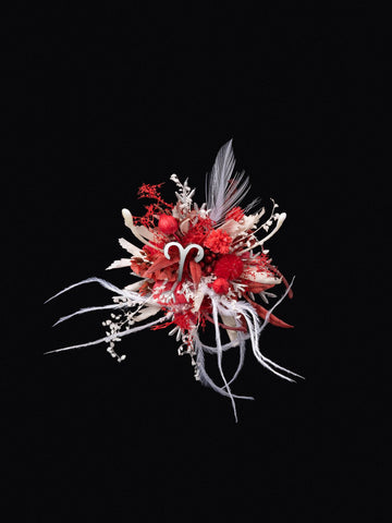 The Aries Flower Ring by CAMELLIA showcases a vibrant, abstract floral arrangement with red, white, and pink elements handcrafted from feathers and curly ribbons on a black background. This customizable piece adds a unique touch to any setting. The Aries Flower Ring by CAMELLIA showcases a vibrant, abstract floral arrangement with red, white, and pink elements handcrafted from feathers and curly ribbons on a black background. This customizable piece adds a unique touch to any setting.