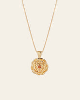 The Elsa Carnation Garnet Necklace by CAMELLIA is a gold necklace with a rose-shaped pendant featuring an amber gemstone. Handcrafted in New York, it highlights exquisite artistry and detail.