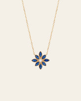 The Cámellia Sapphire Pearl Necklace by CAMELLIA showcases a blue and pearl flower-shaped pendant with seven petals, set against a plain white background.