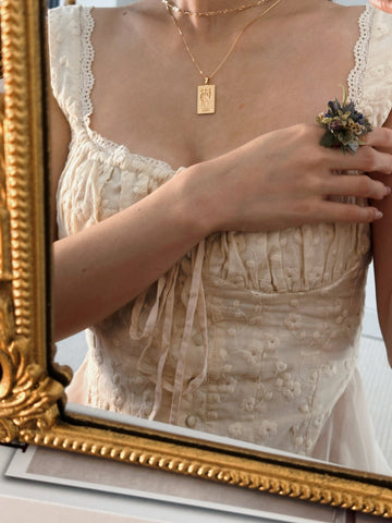 In an ornate gold-framed mirror, a woman wearing a cream floral corset dress is adorned with customizable jewelry, including CAMELLIA's Customized Basic Flower Ring. Her hand rests near the elegant brooch, capturing New York's handcrafted uniqueness for those who cherish distinctive style. In an ornate gold-framed mirror, a woman wearing a cream floral corset dress is adorned with customizable jewelry, including CAMELLIA's Customized Basic Flower Ring. Her hand rests near the elegant brooch, capturing New York's handcrafted uniqueness for those who cherish distinctive style.