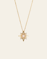 The CAMELLIA New York Opal Pentagram Necklace is a 14K yellow gold vermeil piece with a star-shaped pendant featuring a central pink stone, surrounded by shimmering clear stones on a delicate chain.