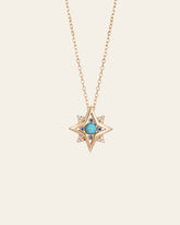 The New York Turquoise Pentagram Necklace by CAMELLIA is a handcrafted gold chain piece with a star-shaped pendant, central turquoise stone, and small clear stones at the tips.