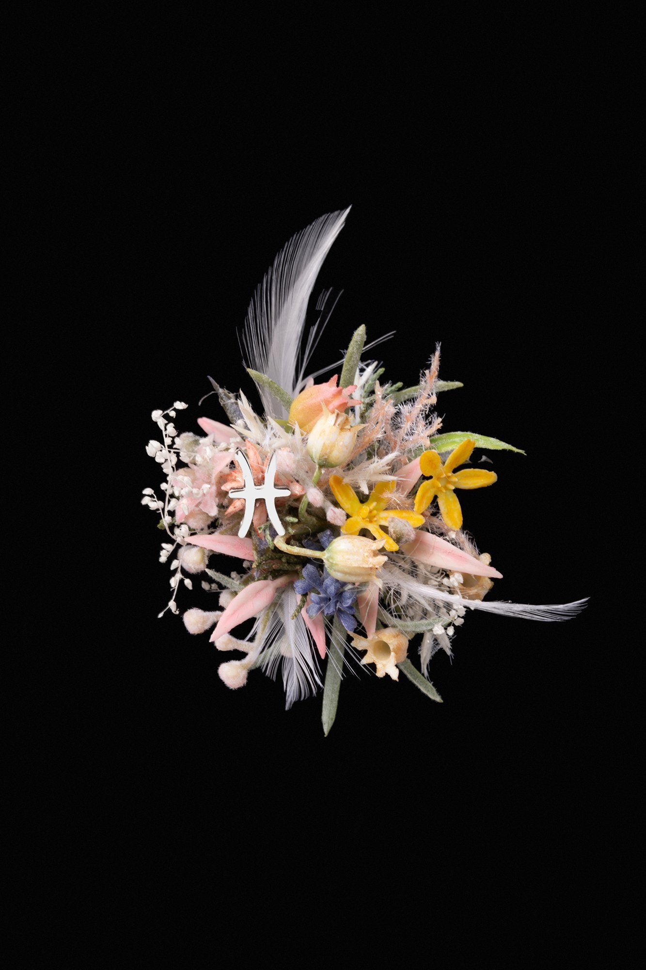 A vibrant bouquet of mixed flowers and feathers, with pink, yellow, and white petals on a black background, resembles the Pisces Flower Ring by CAMELLIA—a handcrafted masterpiece capturing the essence of beauty like a custom symbol flower ring designed in New York.