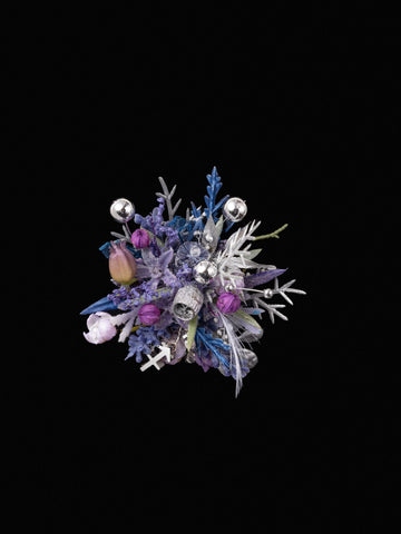 The Sagittarius Flower Ring by CAMELLIA exudes elegance with its purple and silver flowers, silver ornaments, and lush greenery set against a black background, creating a handcrafted masterpiece. The Sagittarius Flower Ring by CAMELLIA exudes elegance with its purple and silver flowers, silver ornaments, and lush greenery set against a black background, creating a handcrafted masterpiece.