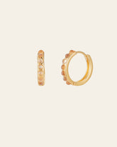 The Una Moonstone Hoops by CAMELLIA are two gold hoop earrings crafted from 14K Yellow Gold Vermeil, adorned with round orange gemstones along the outer edge and presented on a plain background.