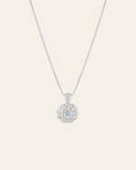 The Elsa Marigold Tourmaline Necklace by CAMELLIA is expertly crafted from hypoallergenic sterling silver and highlighted with a flower-shaped pendant featuring a central light blue gemstone.