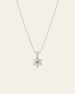 The CAMELLIA Elsa Lily Emerald Necklace features a sterling silver star-shaped pendant with a green gemstone centerpiece. Handcrafted in New York, this elegant piece embodies simplicity and style.