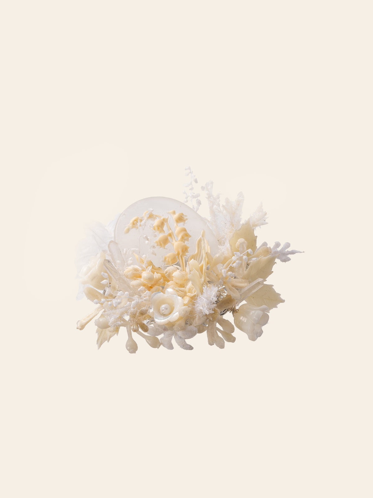 The Lily of the Valley Birth Flower Ring by CAMELLIA features an intricate design of white and cream flowers and leaves set on a light background, handcrafted in New York.