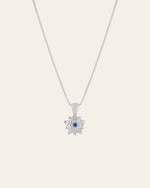 The CAMELLIA Elsa Holly Tanzanite Necklace features a sterling silver flower-shaped pendant with a center tanzanite gemstone. It's hypoallergenic, offering comfort throughout the day.