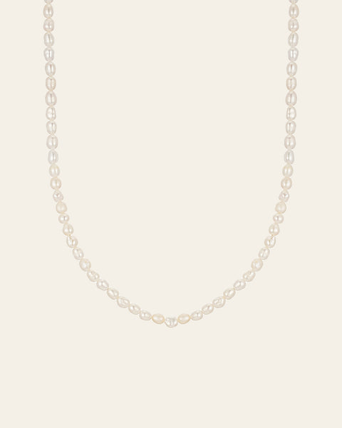 The CAMELLIA 3mm Pearl Chain Necklace features a strand of white pearls elegantly paired with a 14K Yellow Gold Vermeil clasp, set against a plain light background.