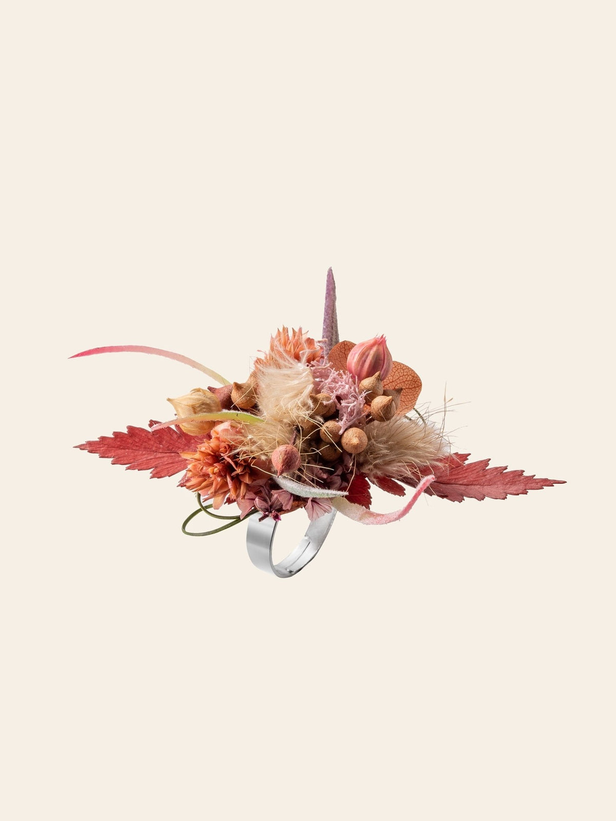 The CAMELLIA Saffron Blush Flower Ring features an arrangement of dried flowers, leaves, and sprigs in red, orange, and beige against a plain background.