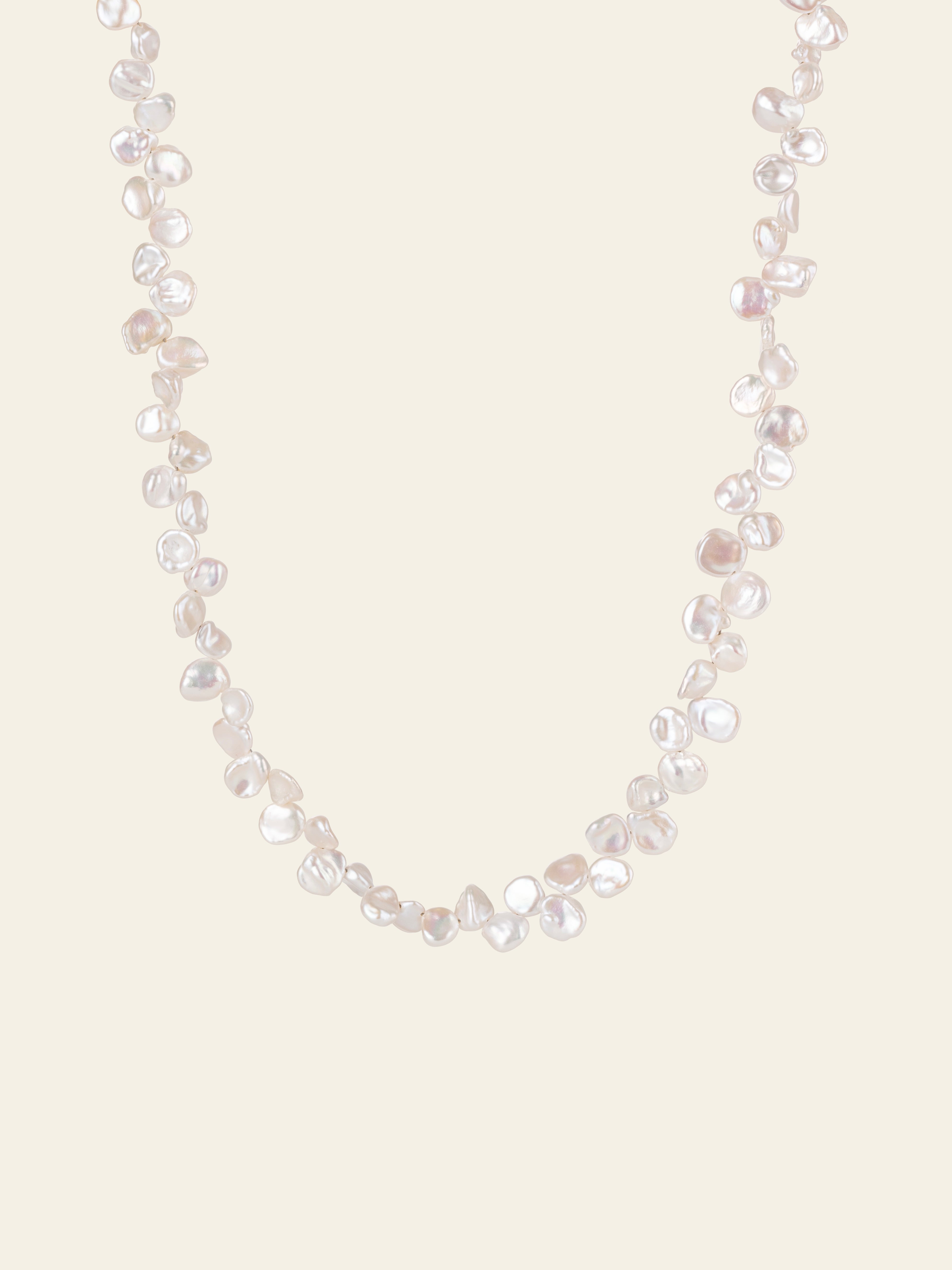 The CAMELLIA Petal Pearl Necklace showcases irregularly shaped white freshwater pearls arranged on a simple, light background.