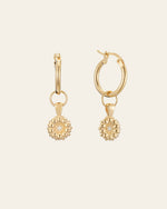 The CAMELLIA Elsa Daisy Diamond Earrings are meticulously handcrafted in New York, featuring spherical, beaded pendants hanging from gold hoops.