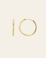 The 25mm Mother Hoops by CAMELLIA are showcased on a plain background, featuring one earring side view and the other front view. Crafted in 14K Yellow Gold Vermeil, they are hypoallergenic for sensitive ears and add a timeless touch to any ensemble.
