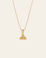 The Elsa Violet Amethyst Necklace by CAMELLIA is a handcrafted gold pendant necklace with intricate designs and small gemstones, elegantly suspended on a fine chain, set against a plain background.